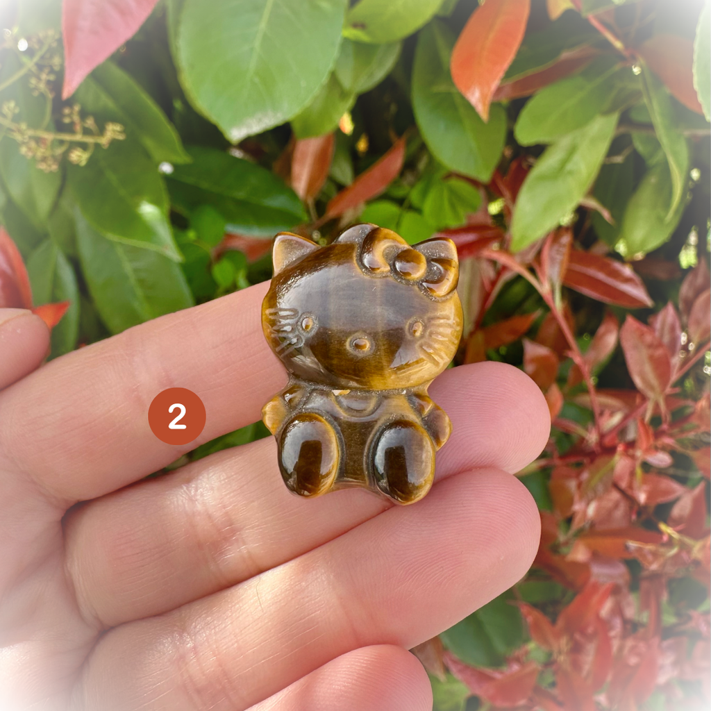 boutique de Mamie Lucie, Hello Kitty en œil de tigre, figurine Hello Kitty, œil de tigre, pierre naturelle, lithothérapie, pierres naturelles, minéraux naturels, bien-être, protection énergétique, confiance en soi, courage, force intérieure, ancrage, énergie positive, équilibre émotionnel, méditation, Saint-Louis, Bâle, Strasbourg, Colmar, Mulhouse, Dietwiller, Obersaasheim